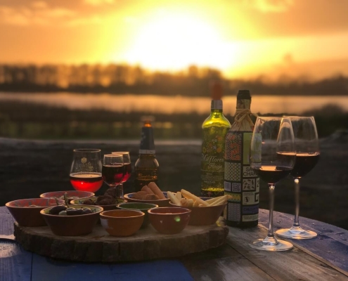 Hapjes en wijn op het terras van el Chiringuito met uitzicht over het meer Geestmerambacht met zonsondergang